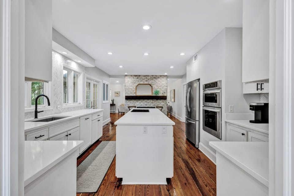 The gourmet kitchen is a chef's delight, featuring a spacious island, high-end stainless steel appliances, and functional lighting.