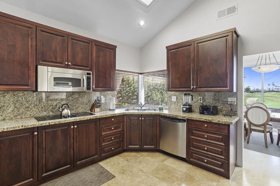 Spacious kitchen w/ wood cabinetry, granite counters & plenty of room to cook
