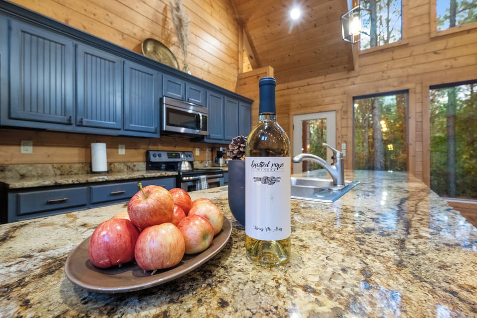 The combination of striking blue cabinets, sleek granite counters, and top-of-the-line appliances brings a touch of luxury to your rustic getaway, making every meal prep a delight.  