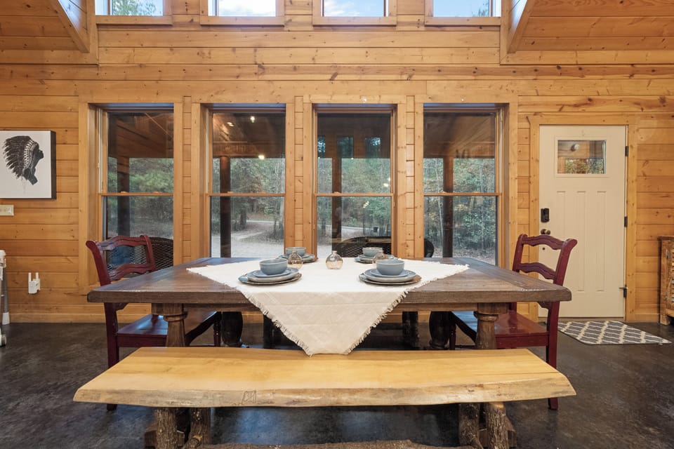 Enjoy your meals with a stunning forest backdrop, thanks to a wall of windows that brings the beauty of nature right to the dining table.