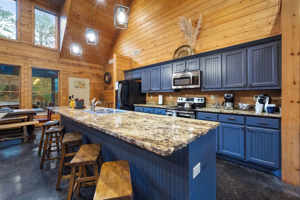 The spacious kitchen island is perfect for family meals or casual chats. With seating for five, it's the ideal spot to unwind after a day of adventure in Broken Bow.