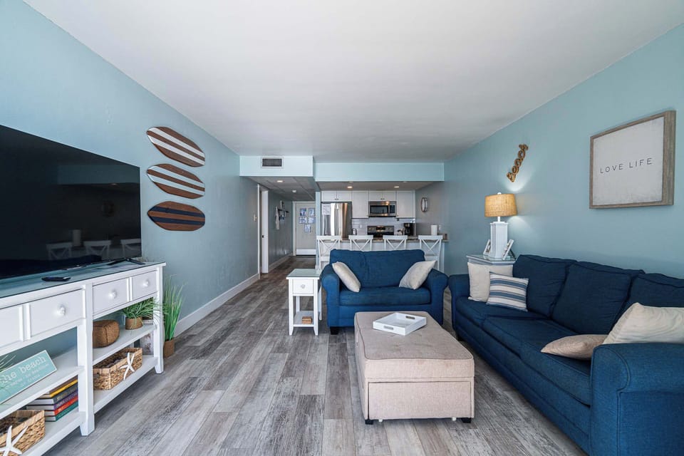 Open living space with sofa sleeper, Smart TV, and balcony access