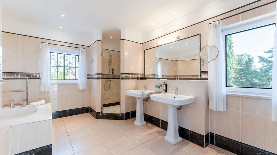 Indulge in relaxation in this spacious, sun-drenched bathroom featuring dual sinks, a luxurious tub, and a refreshing walk-in shower.
#Bathroom #LuxuryBath #LovelyStay
