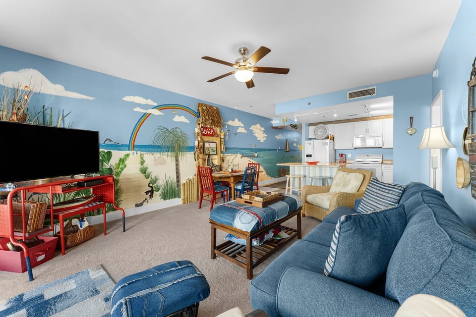 Relax in this colorful living room featuring a tropical mural and comfortable seating.