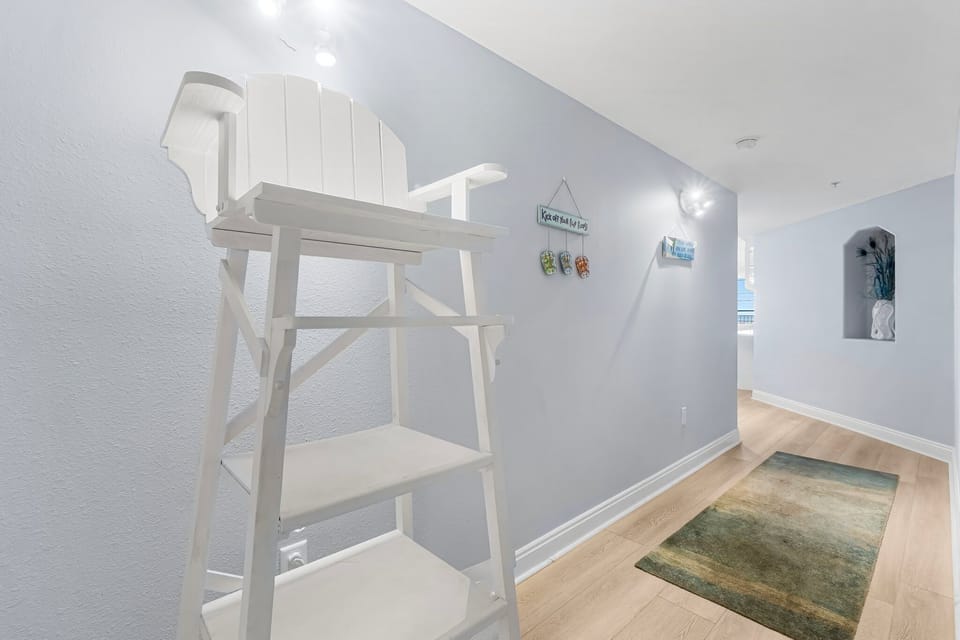 hallway with a white wooden lifeguard chair and coastal decor