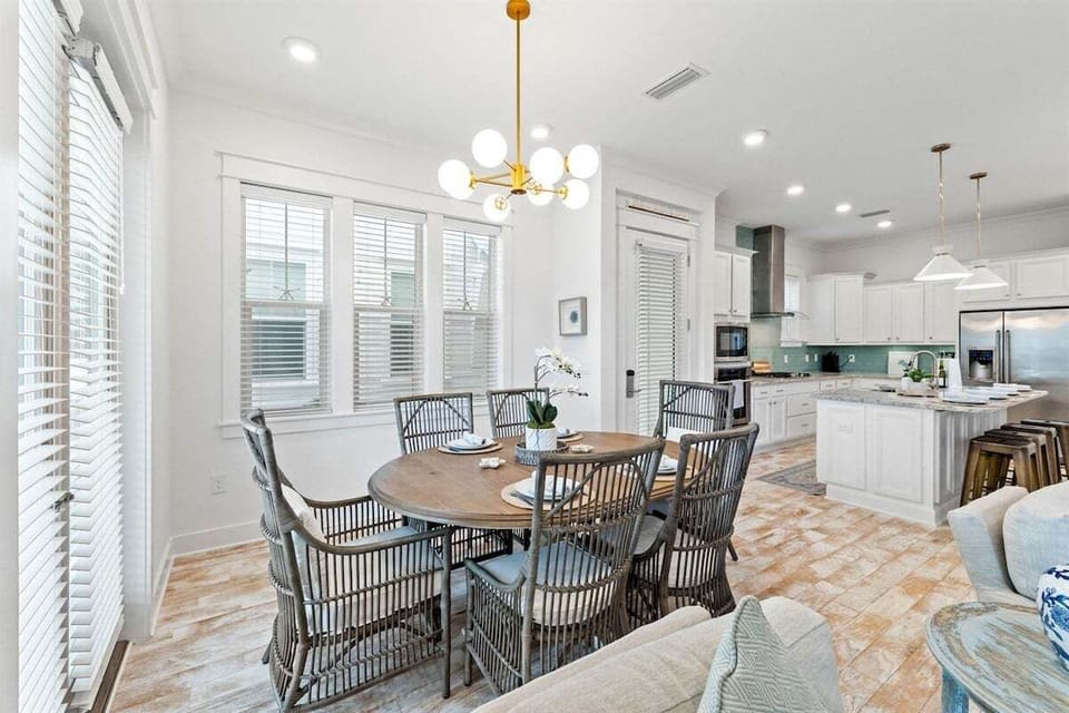 A beautifully set dining area featuring floor-to-ceiling windows, bringing in natural light and outdoor views.