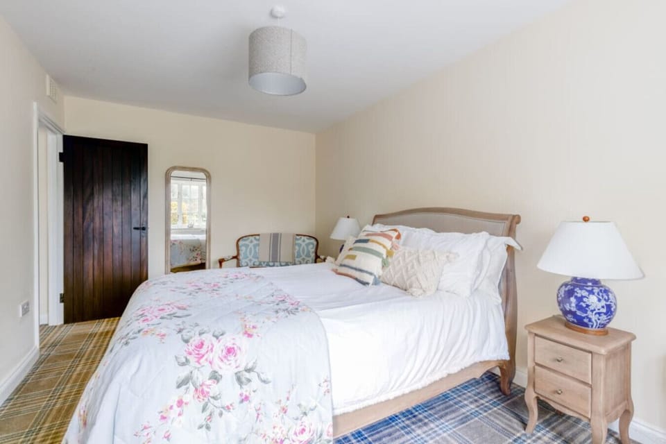 Light-filled king bedroom with soft neutral tones and garden views