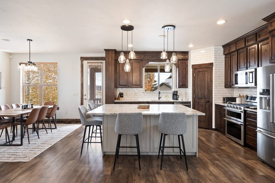 - Modern kitchen with stainless steel appliances and island seating  
- Dining table for group meals and gatherings  
- Bright open layout designed for cooking and entertaining