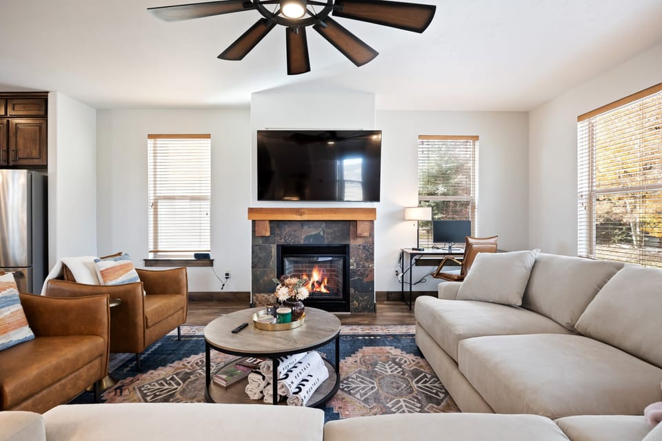 - Modern living space with fireplace and smart TV setup  
- Comfortable sectional sofa for relaxing nights in  
- Workstation by the window for remote work convenience