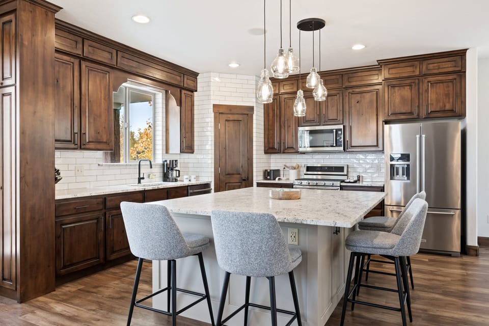 - Modern kitchen with granite island and pendant lighting  
- Stainless steel appliances and rich wood cabinetry  
- Spacious layout ideal for cooking and entertaining