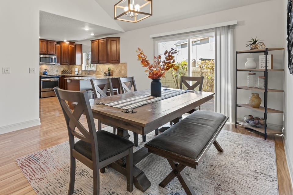 Inviting dining space with a rustic farmhouse table and seating for 7 plus additional seating at the kitchen bar.  Sliding doors lead to the back deck and patio area with a fire pit and BBQ.