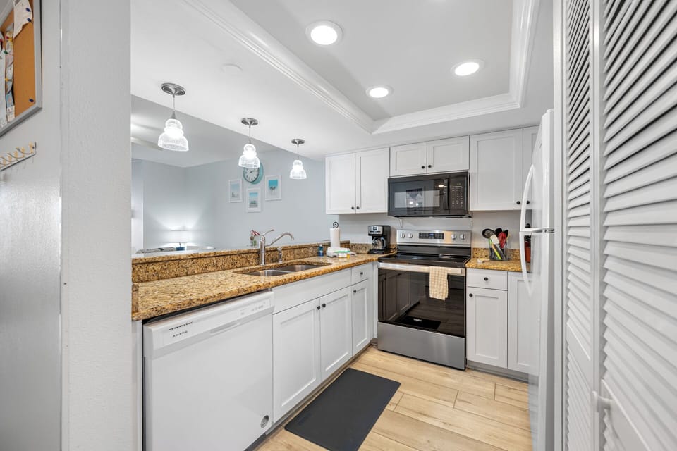 Fully equipped kitchen with granite countertops, stainless steel appliances, and plenty of counterspace for cooking and preparing meals