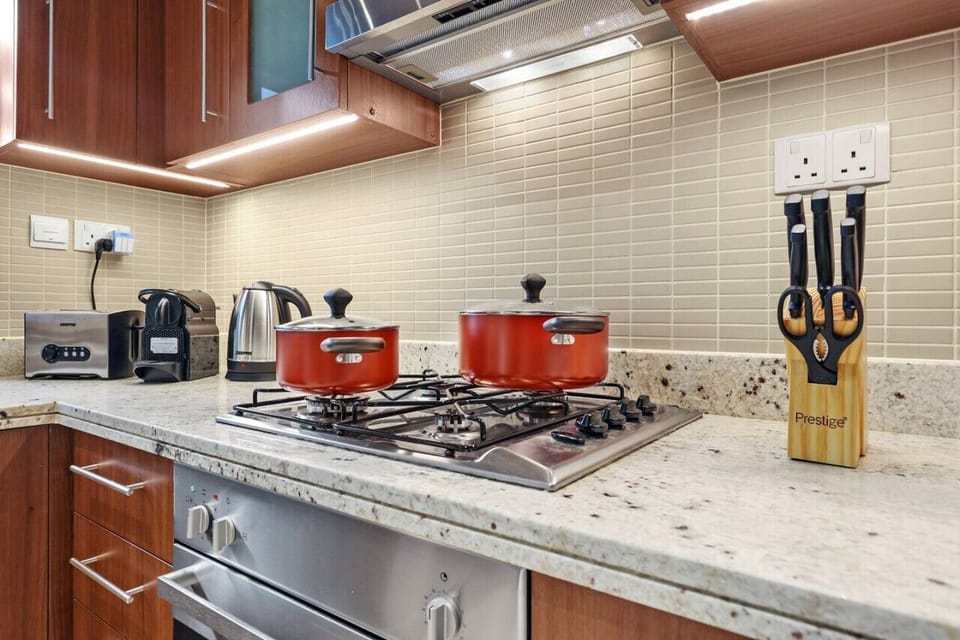 Kitchen: Sleek countertops and vibrant cookware make cooking a delight in Dubai!