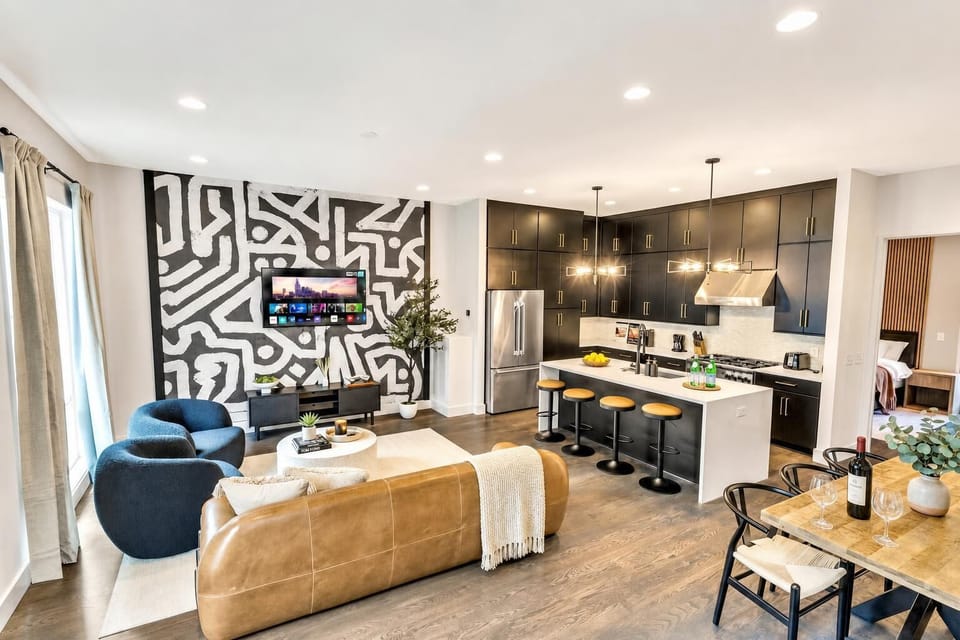 From the kitchen island, you can see the dining table, the living room, and the sofa all at once. This is the honky-tonk house that keeps twelve people together