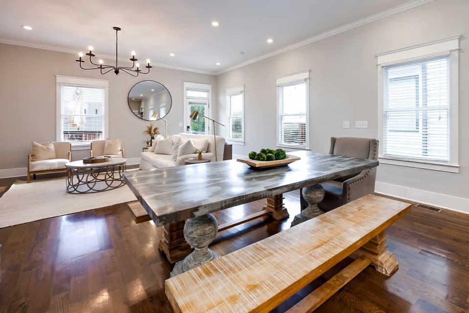 Dining table with bench seating keeps the whole group eating together, hardwood floors and natural light making it feel like everyone matters at dinner