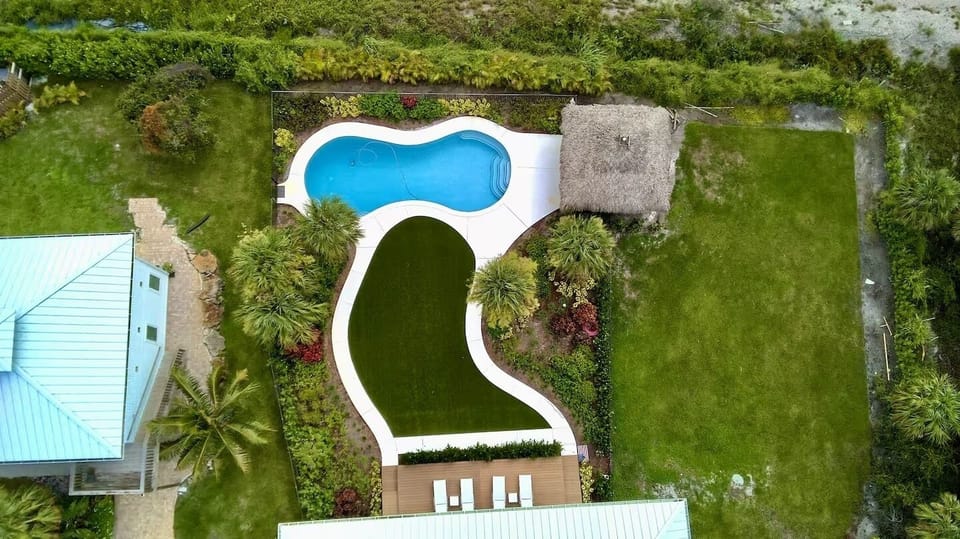 Birds eye view of main house back yard and cottage to left
