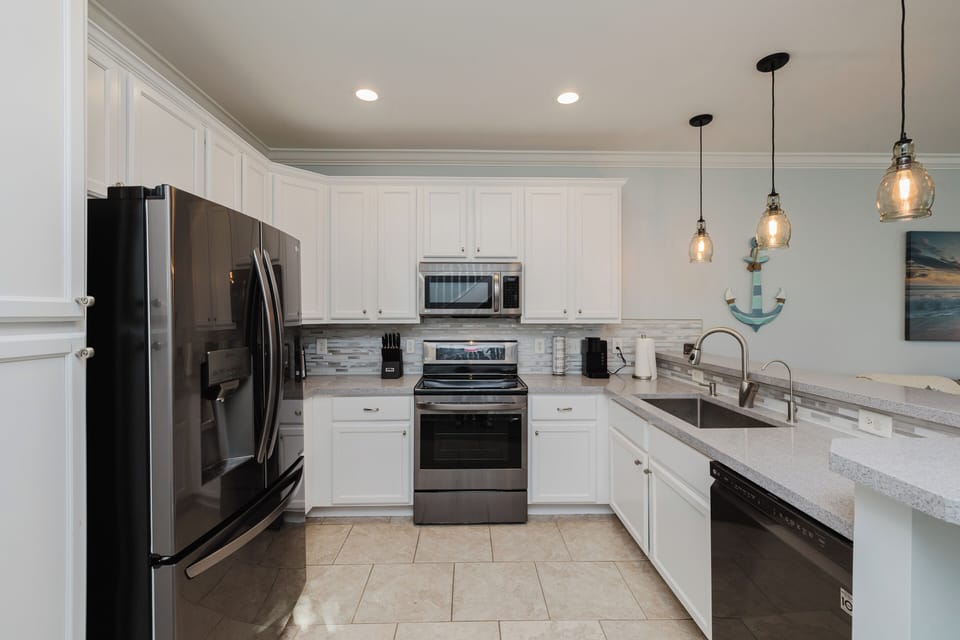 Modern kitchen fully stocked with cookware, an air fryer, Keurig and standard coffee maker, and everything needed for cooking meals and entertaining.