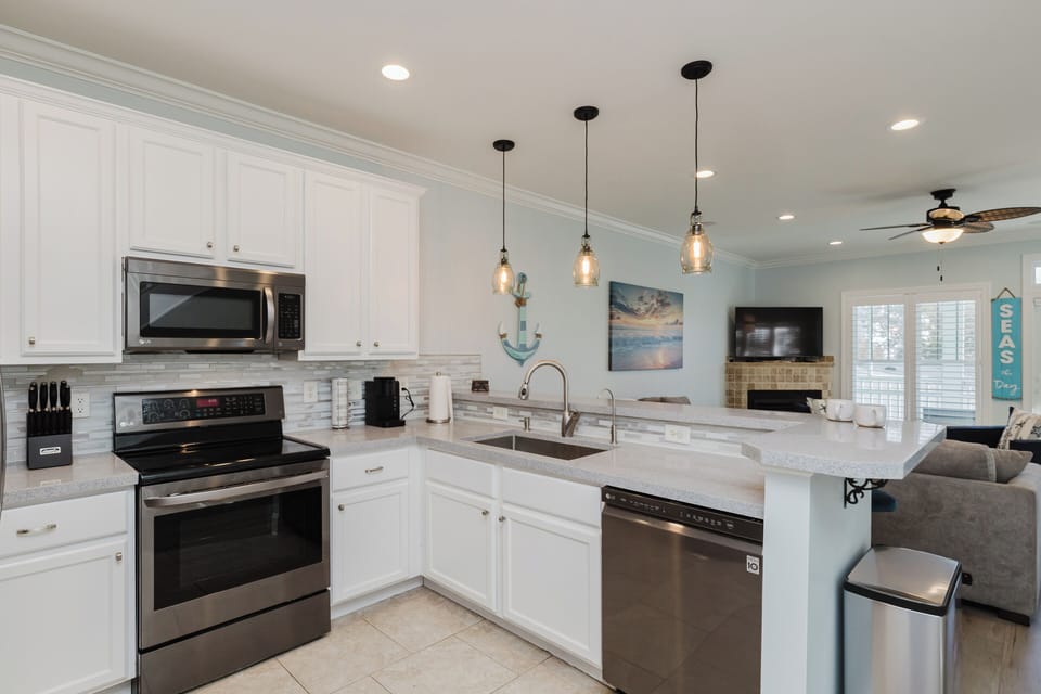 Modern kitchen fully stocked with cookware, an air fryer, Keurig and standard coffee maker, and everything needed for cooking meals and entertaining.