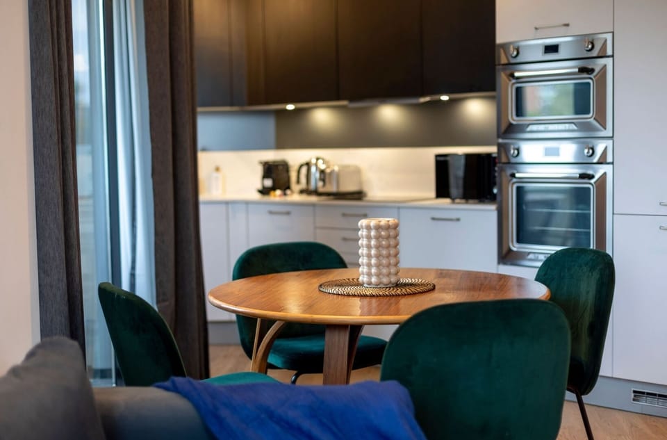 Spacious open living area with a connected kitchen, a stylish dining table, a comfortable sofa bed and Smart TV