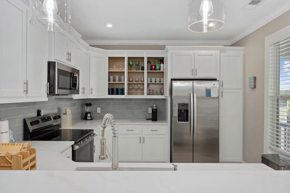 Make cooking fun again in this fully stocked kitchen with sleek, modern appliances, a large island for extra workspace, and a design that flows perfectly into the rest of the home