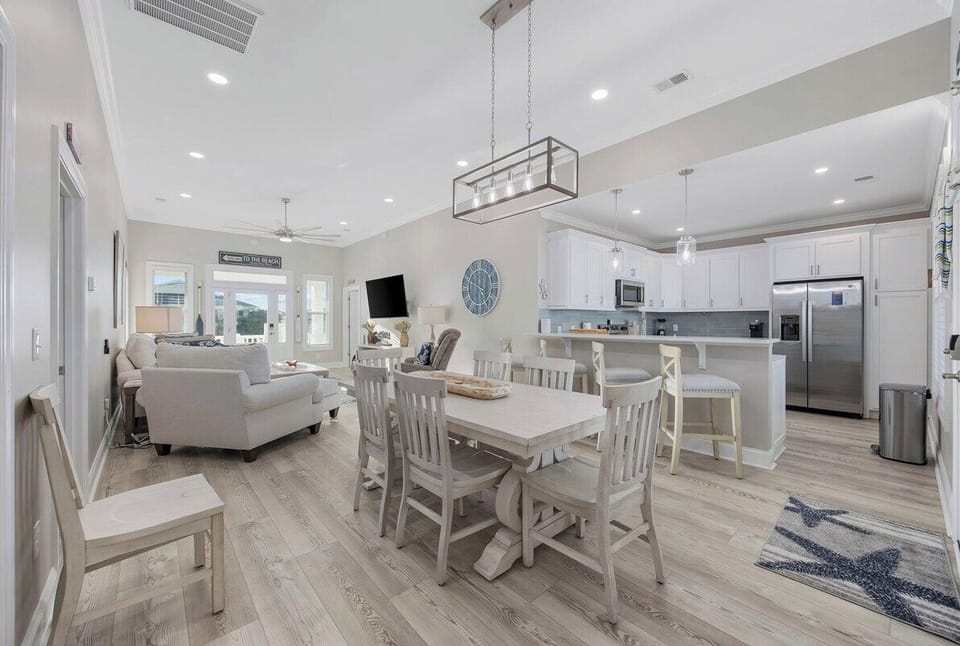 The heart of the home: A spacious dining table with room for everyone to enjoy a meal together, complemented by coastal-inspired decor and natural light.
