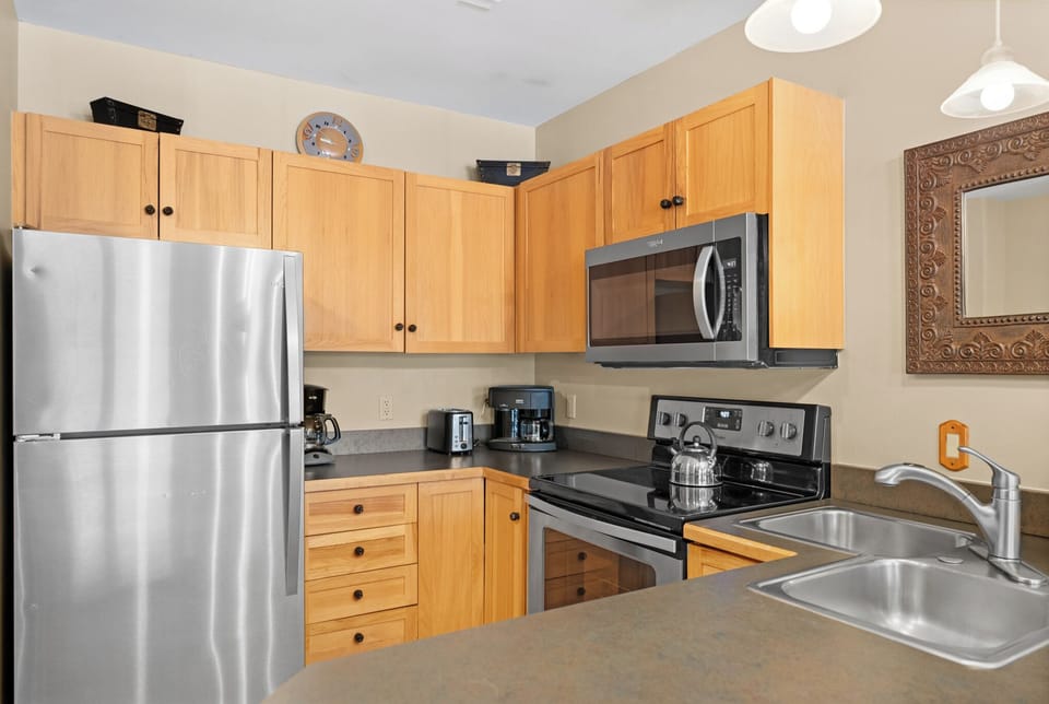 Your fully equipped kitchen awaits with modern stainless steel appliances, warm wood cabinetry, and everything you need to create delicious home-cooked meals during your stay.