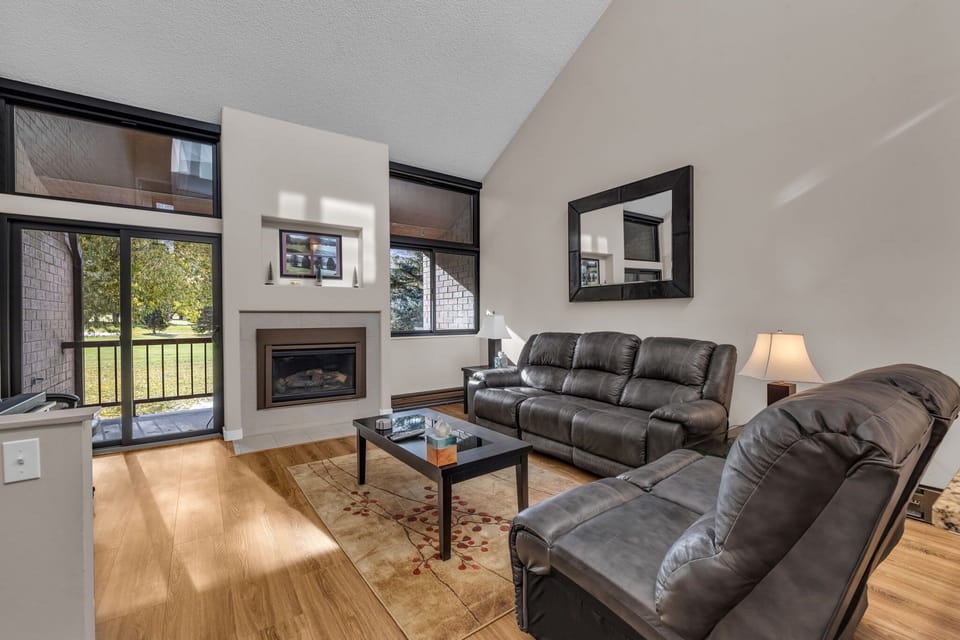 Living Room: Leather couch, loveseat, 50” Smart TV w/cable, sound bar, subwoofer behind couch, gas fireplace, access to balcony