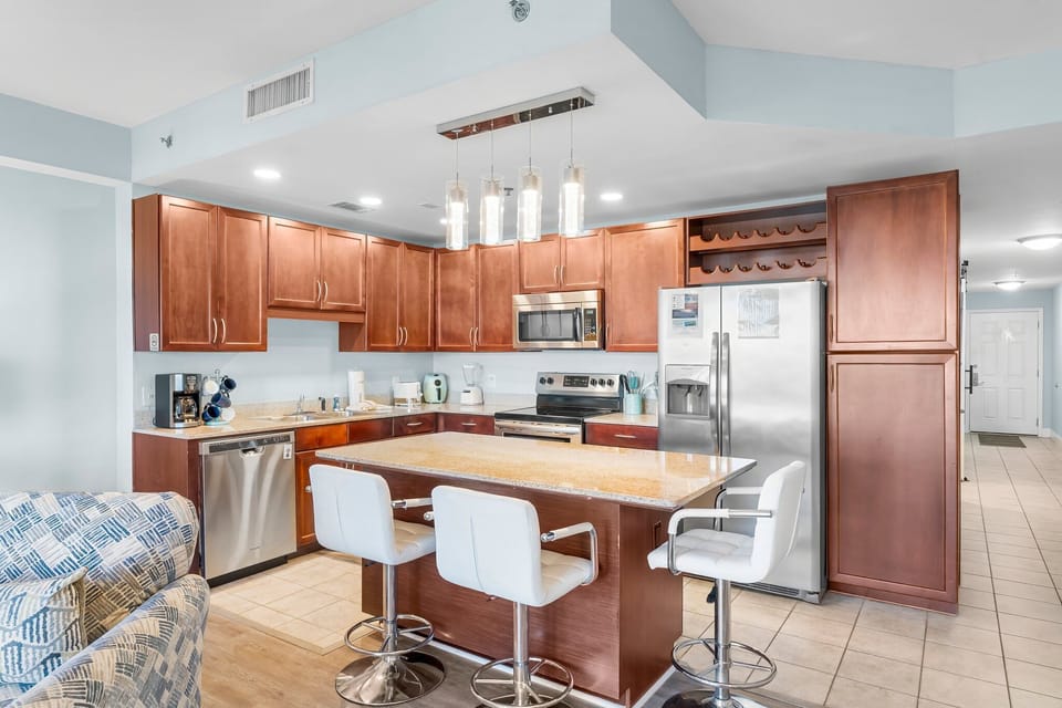 Modern kitchen with stainless steel appliances and a central island with seating.