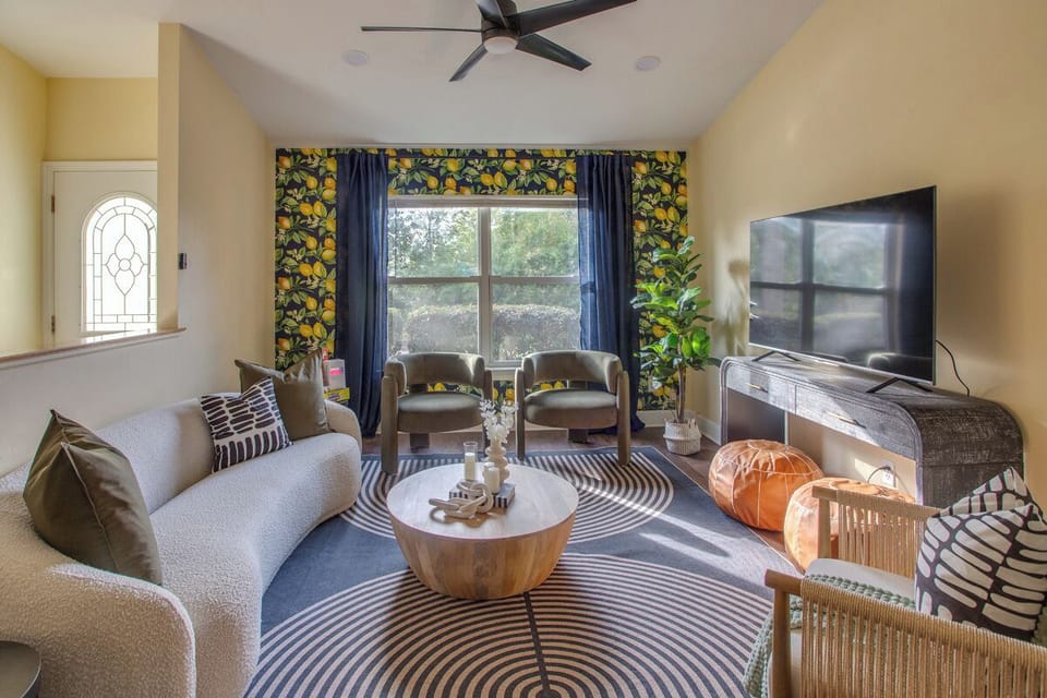 Living room with ceiling fan, TV, and plush seating