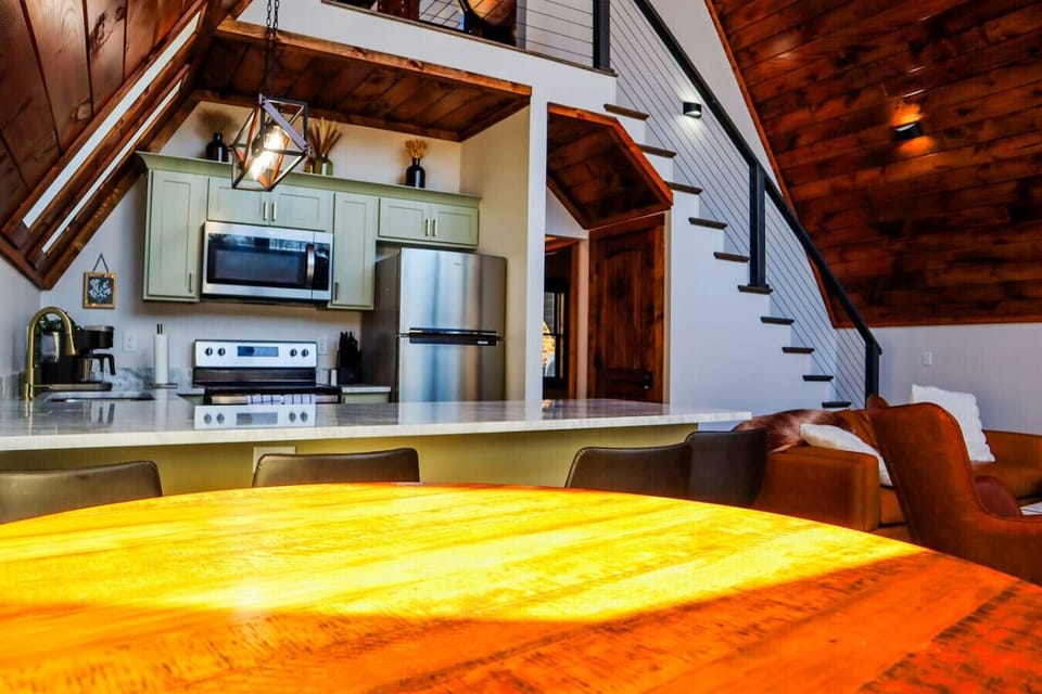 Gather around the dining table beside the fully equipped kitchen and open-concept living space