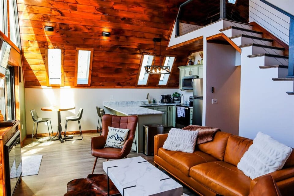 Soaring A-frame ceilings and an open-concept living space filled with natural light