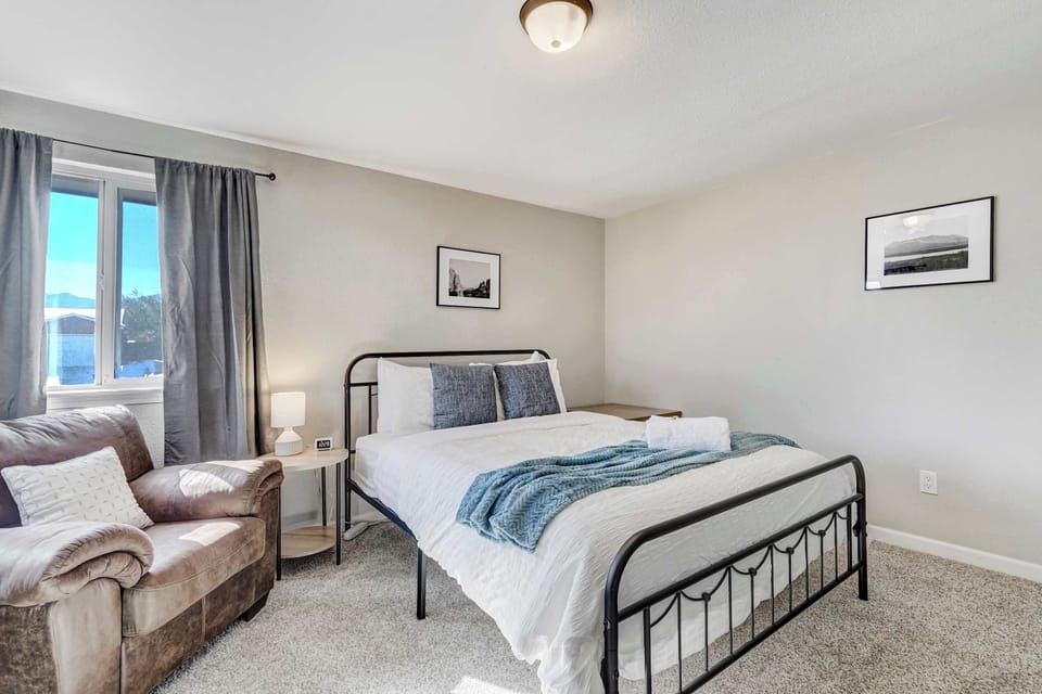 Cozy Bedroom with Reading Nook – Relax in this inviting queen bed with soft linens and a comfortable chair for quiet moments.