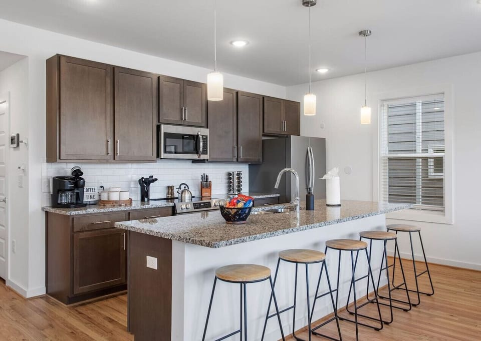 Cook, chat, and sip in this bright, fully stocked kitchen! With a spacious island and barstool seating, plus a Keurig to kickstart your mornings.