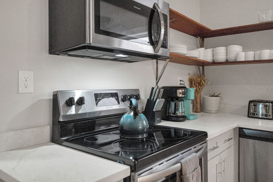 Fully equipped and ready for your culinary creations! Enjoy the convenience of a modern kitchen with all the essentials, including a coffee maker, toaster, and sleek appliances.