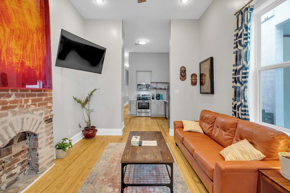 Unwind in this vibrant living room where modern comforts meet classic New Orleans charm. Relax on the plush leather sofa, enjoy a movie on the mounted TV, and take in the character of the exposed brick and eclectic decor. This is the perfect space to recharge after exploring the city!