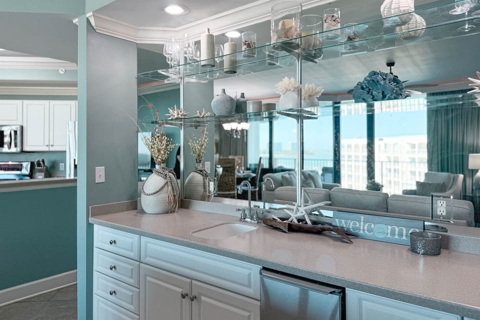 Complete with a stylish wet bar, this space is perfect for mixing up your favorite drinks. The mirrored backdrop and coastal decor create an inviting and elegant atmosphere for entertaining.