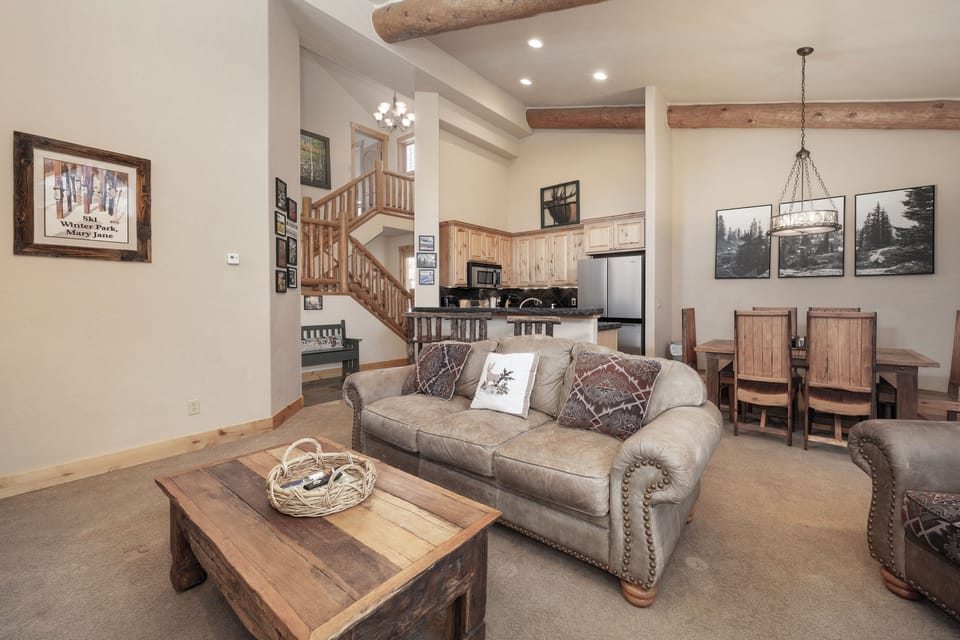 - Open concept living area with mountain lodge design   - Comfortable sofa seating with rustic wood furniture   - Perfect for families to gather and enjoy alpine views