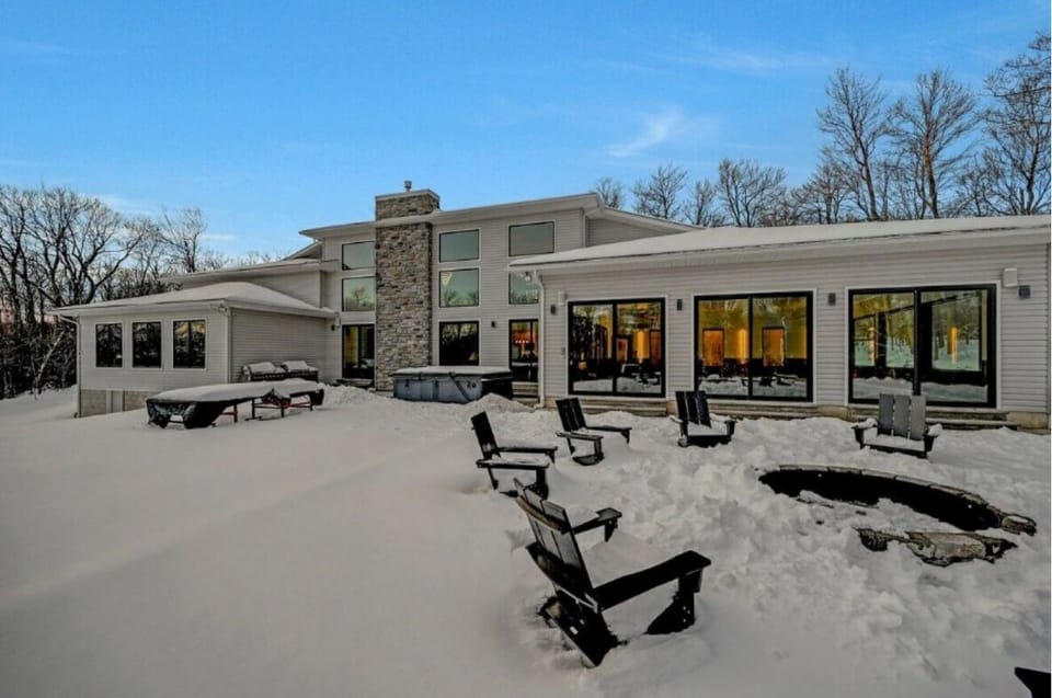 Spacious backyard with fire pit, seating, and snow-covered outdoor area.