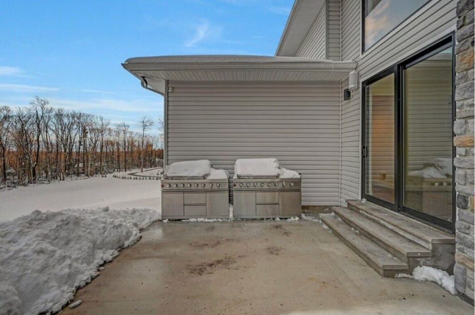 Outdoor grilling area with dual BBQs and easy access from the home patio.