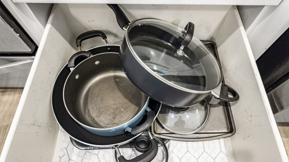 Organized cookware with large pots, skillets, and glass lids, perfect for any meal