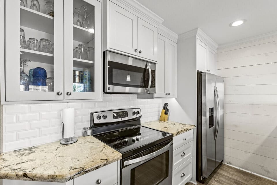 Elegant kitchen with stainless steel appliances and glass cabinets