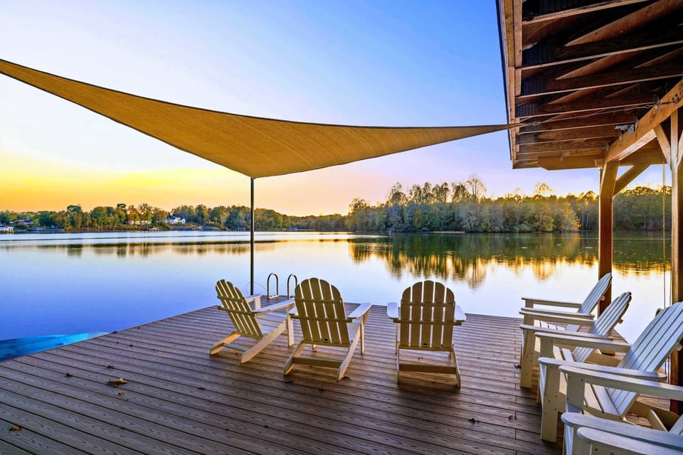 Dock - Golden hour settles over the lake as Adirondack chairs and the covered boathouse catch the last light of the day.