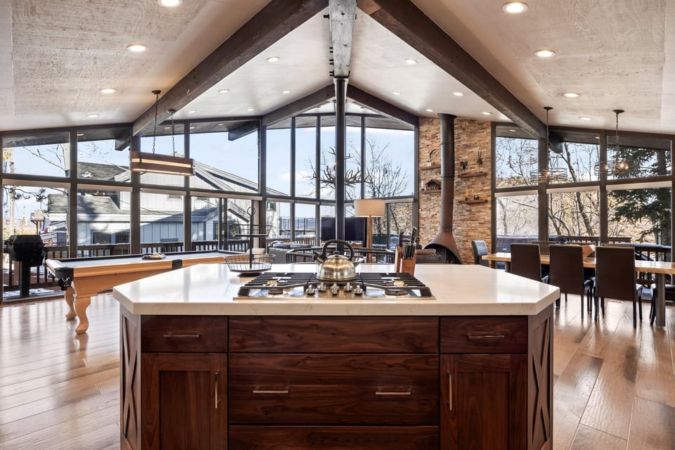 - Open kitchen island view showcases bright mountain inspired design  
- Large windows fill the space with natural light and scenic views  
- Rustic beams and fireplace complete the mountain modern atmosphere