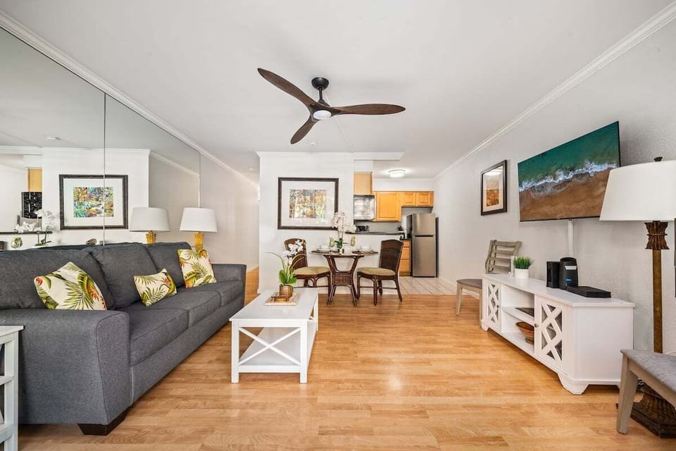 Spacious living room with gray sofa, open layout, and flat‑screen TV.