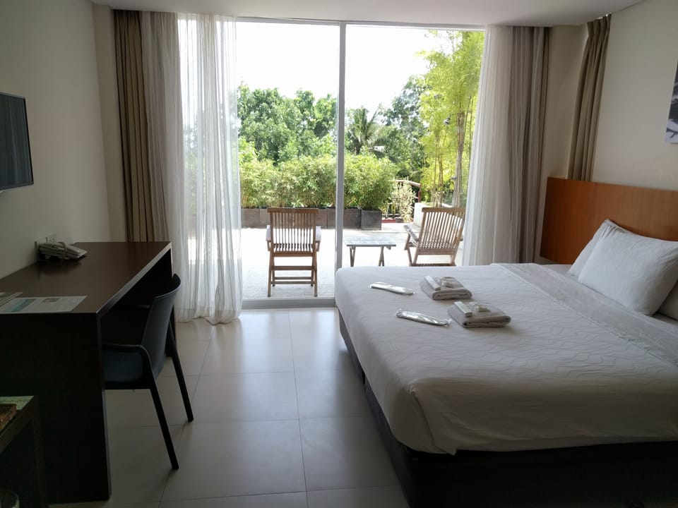 Deluxe Suite, Pool View | Minibar, in-room safe, desk, laptop workspace