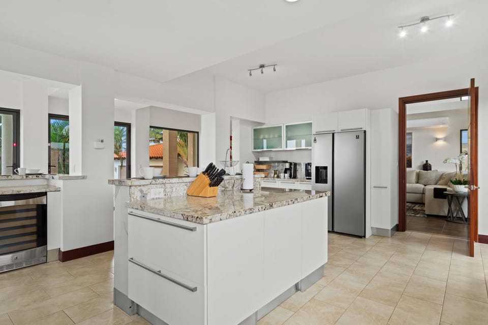 This open-concept kitchen boasts a spacious island perfect for prepping meals or gathering with friends - Elegant granite surfaces blend comfort with practicality - A seamless flow connects the kitchen to the spacious living and dining areas