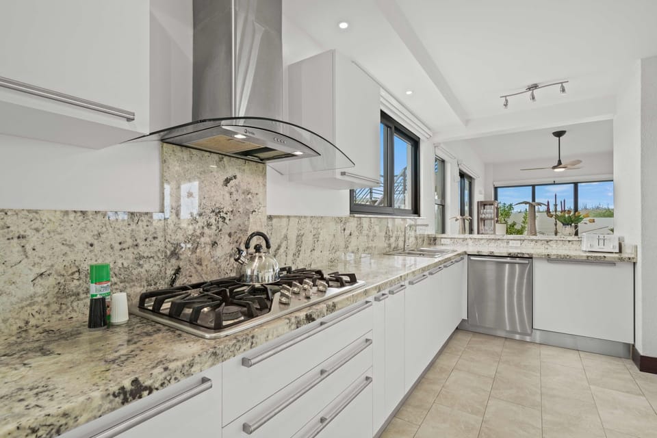 Cook like a pro in this modern kitchen, featuring gleaming granite counters and a chic gas stove - The streamlined design offers extra space for prepping meals with ease - A perfect balance of function and style for your culinary adventures