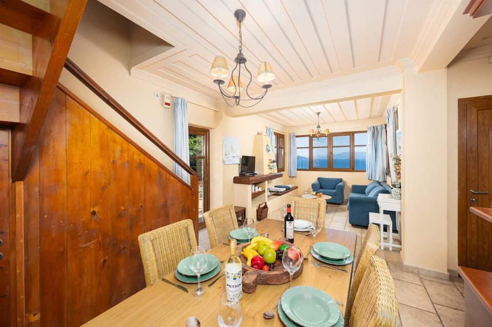 Open-plan living room with sofa, dining area, kitchen, A/C, WiFi internet, and satellite TV