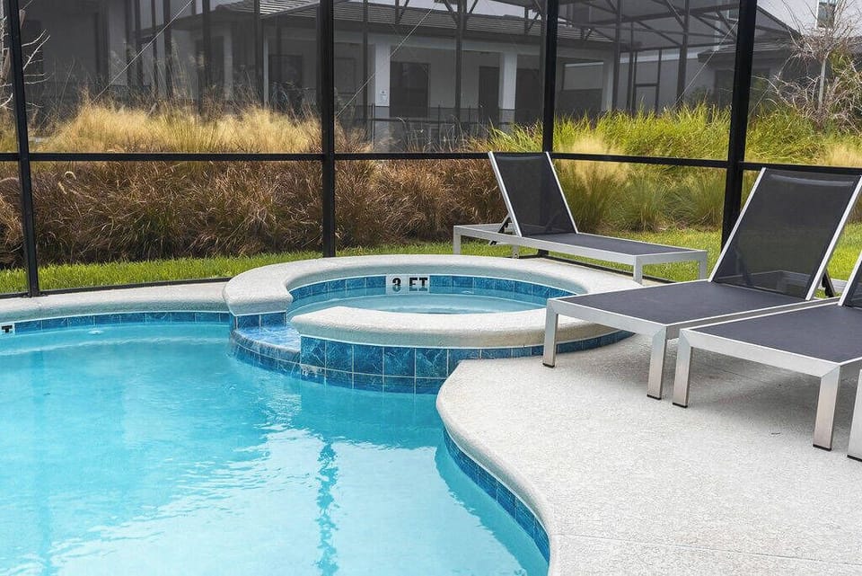 Step into relaxation with a private pool area featuring a soothing spa and sleek lounge chairs. The serene blue water invites you to unwind, while the surrounding greenery adds a touch of natural beauty to your escape.