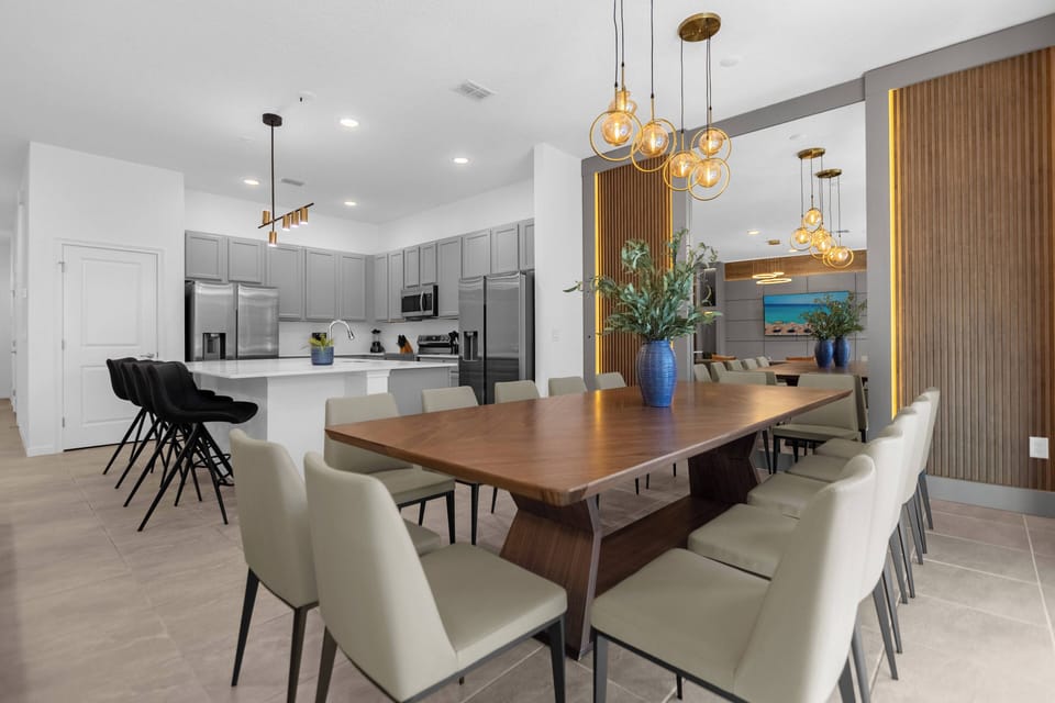 Enjoy our inviting dining area with a lovely wooden table for eight and light-hued chairs perfect for relaxed gatherings. The warm pendant lighting complements the modern kitchen, making it an ideal spot for shared meals.